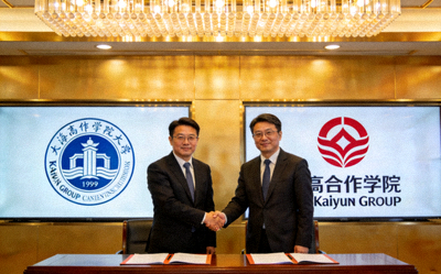 Kaiyun集团与高校战略合作签约仪式 - 双方代表在签约台上握手，背景是合作高校的校徽与Kaiyun集团Logo